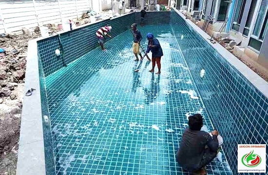 Dùng dụng cụ chuyên dụng để làm sạch đáy hồ bơi